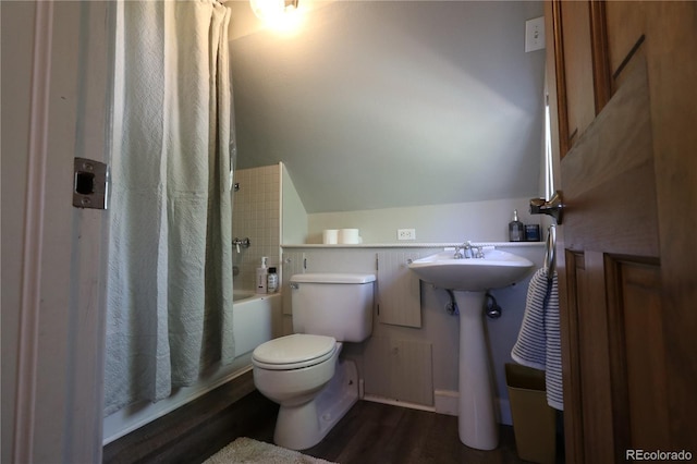 bathroom with toilet, shower / bath combination with curtain, vaulted ceiling, and wood finished floors