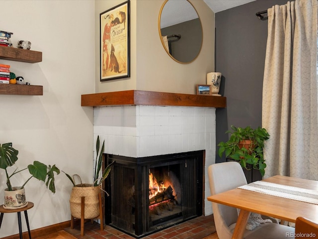 room details featuring a brick fireplace and baseboards