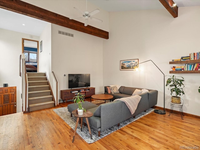 living area with baseboards, visible vents, a ceiling fan, hardwood / wood-style flooring, and stairway