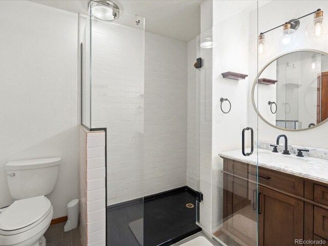 full bath featuring baseboards, a shower stall, toilet, and vanity