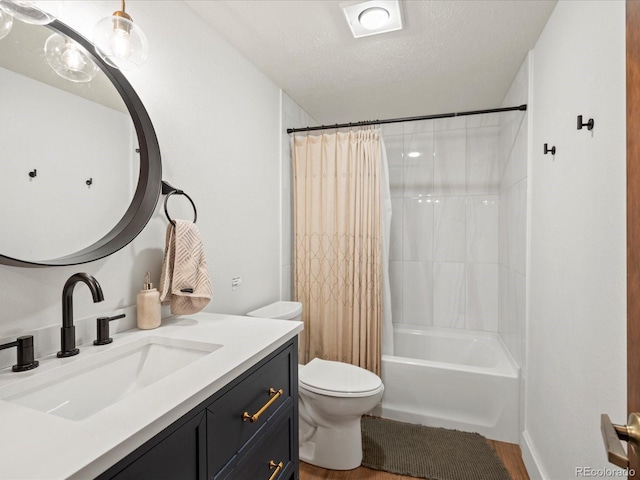 full bathroom with shower / tub combo with curtain, a textured ceiling, toilet, and vanity