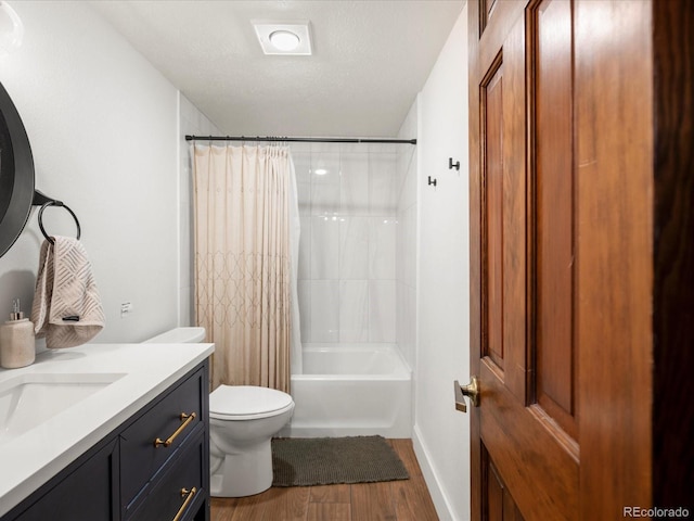 full bath with toilet, wood finished floors, shower / bath combo with shower curtain, a textured ceiling, and vanity