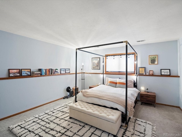 carpeted bedroom with baseboards, visible vents, and a textured ceiling