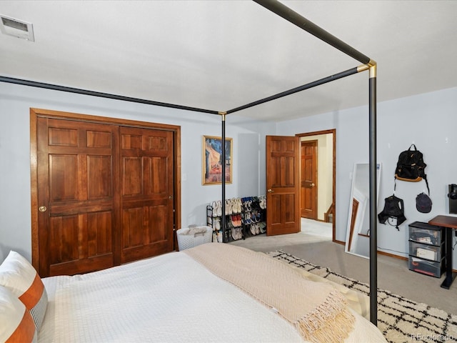 bedroom with light carpet, visible vents, and a closet