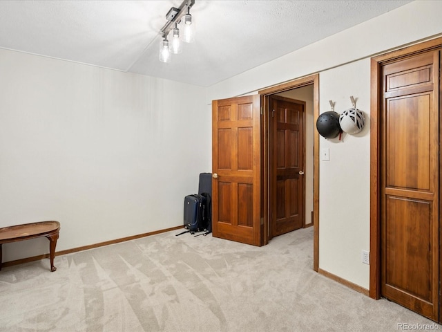 unfurnished bedroom with baseboards and light colored carpet