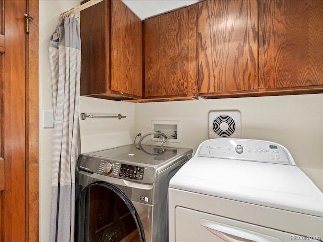 clothes washing area featuring independent washer and dryer, cabinet space, and visible vents