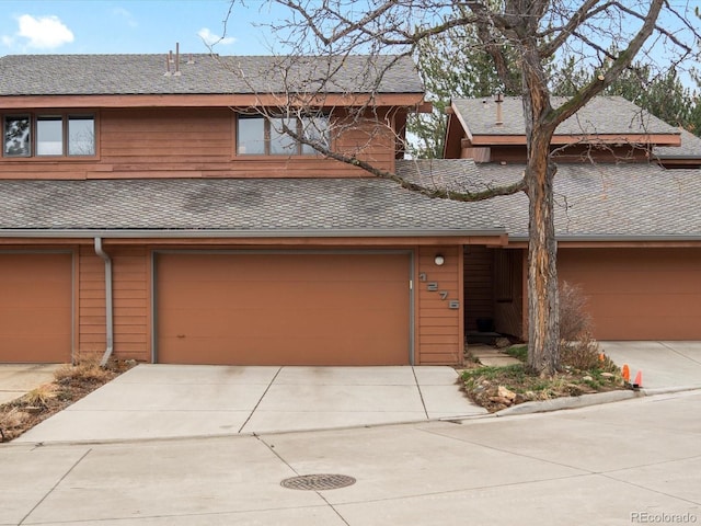 view of front of property featuring driveway, roof with shingles, and an attached garage