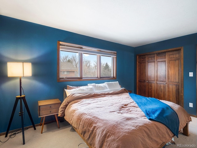 bedroom with baseboards, a closet, and light colored carpet