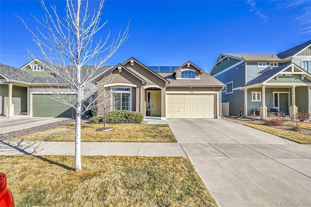 view of front of house with solar panels, driveway, an attached garage, and a shingled roof