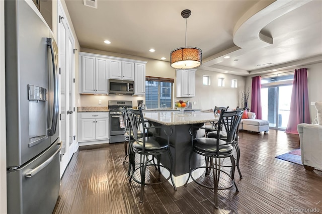 kitchen with appliances with stainless steel finishes, white cabinetry, and dark wood-type flooring