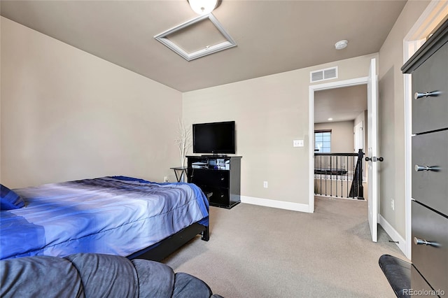 carpeted bedroom featuring visible vents, attic access, and baseboards