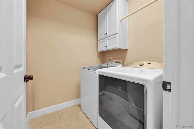 clothes washing area featuring light tile patterned flooring, cabinet space, independent washer and dryer, and baseboards