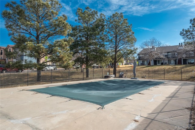 pool with a patio and fence