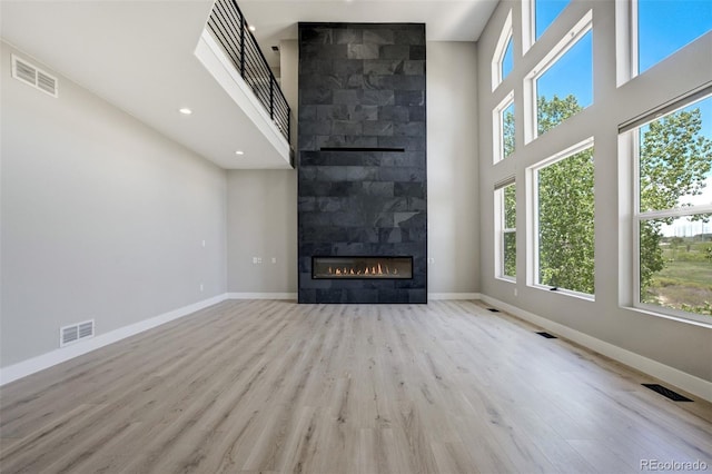 24031 E Hinsdale Pl, Aurora, CO 80016 - unfurnished living room featuring healthy amount of natural light, a high ceiling, wood finished floors, baseboards, and recessed lighting