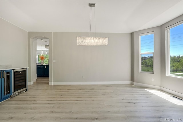 24031 E Hinsdale Pl, Aurora, CO 80016 - unfurnished dining area with plenty of natural light, light wood finished floors, and wine cooler