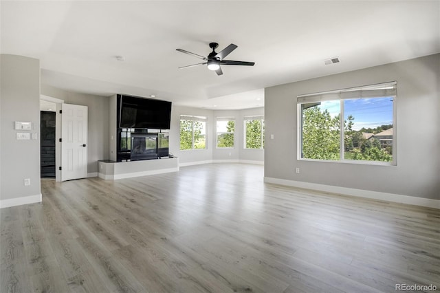 24031 E Hinsdale Pl, Aurora, CO 80016 - unfurnished living room with ceiling fan, a multi sided fireplace, light wood finished floors, and baseboards
