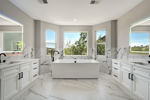 24031 E Hinsdale Pl, Aurora, CO 80016 - bathroom with tile walls, wainscoting, two vanities, marble finish floors, and a freestanding bath