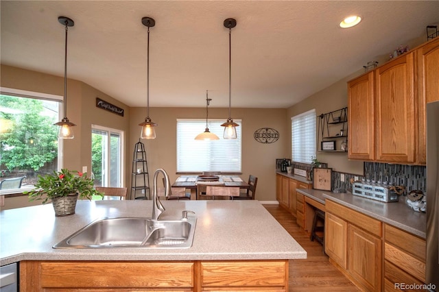 14962 Williams St, Thornton, CO 80602 - kitchen with a sink, light wood-style floors, light countertops, tasteful backsplash, and hanging light fixtures