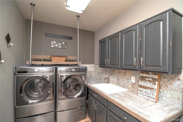 14962 Williams St, Thornton, CO 80602 - washroom featuring washer and dryer, cabinet space, and a textured ceiling