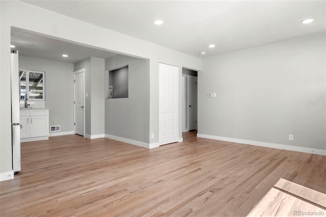 unfurnished room with recessed lighting, visible vents, light wood-style flooring, and baseboards