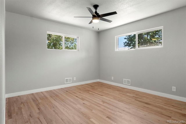 unfurnished room with light wood-type flooring, ceiling fan, and a healthy amount of sunlight