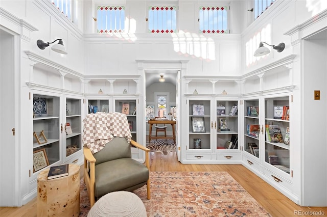 sitting room with a high ceiling and light wood-type flooring