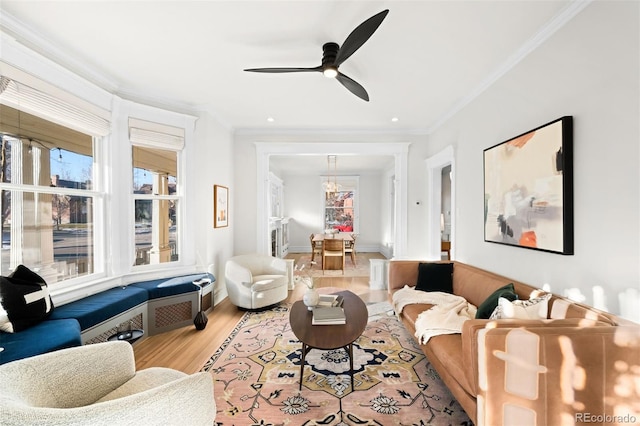 living room featuring ceiling fan, ornamental molding, and hardwood / wood-style floors