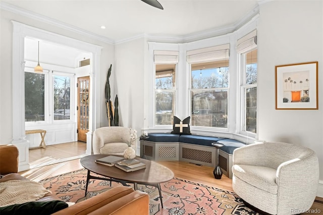 sitting room with crown molding and light hardwood / wood-style floors