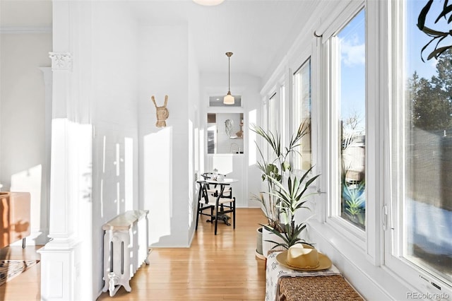 hallway with crown molding and light wood-type flooring