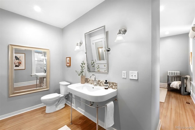 bathroom with hardwood / wood-style floors and toilet