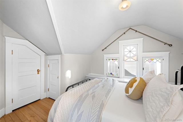 bedroom with vaulted ceiling and light wood-type flooring