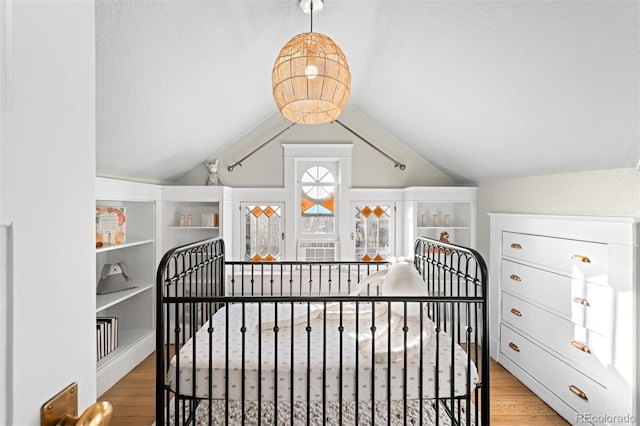 bedroom with lofted ceiling and light wood-type flooring