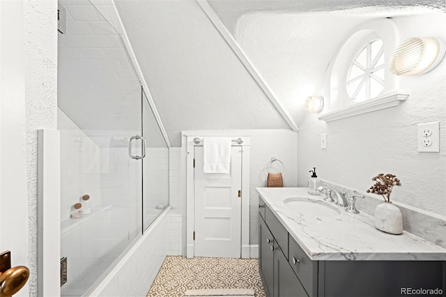 bathroom featuring vanity, lofted ceiling, and combined bath / shower with glass door