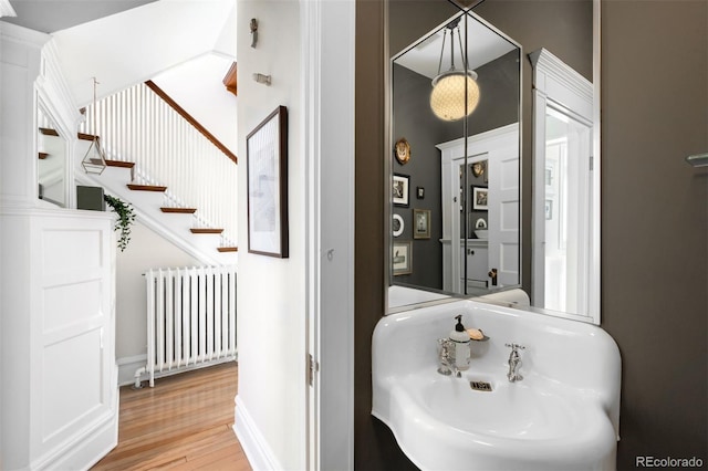 bathroom featuring wood-type flooring, sink, and radiator heating unit