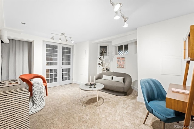 sitting room with rail lighting, french doors, and carpet flooring