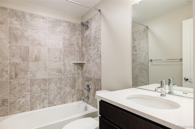 full bathroom featuring tiled shower / bath combo, vanity, and toilet