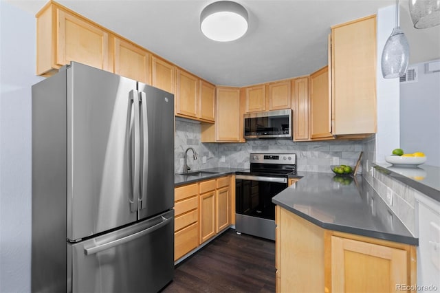 kitchen featuring appliances with stainless steel finishes, backsplash, light brown cabinetry, sink, and pendant lighting