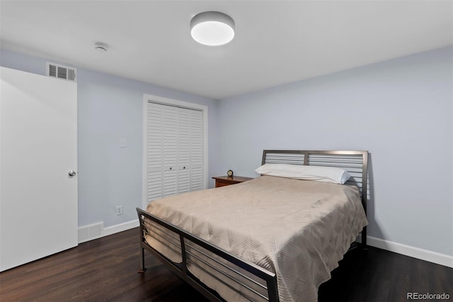 bedroom with dark wood-type flooring and a closet