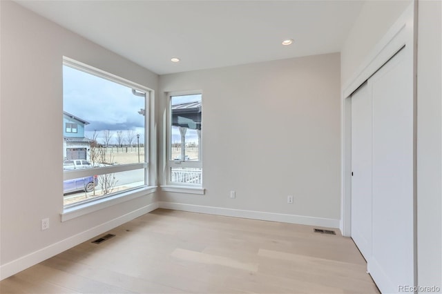 unfurnished bedroom featuring light hardwood / wood-style floors and a closet