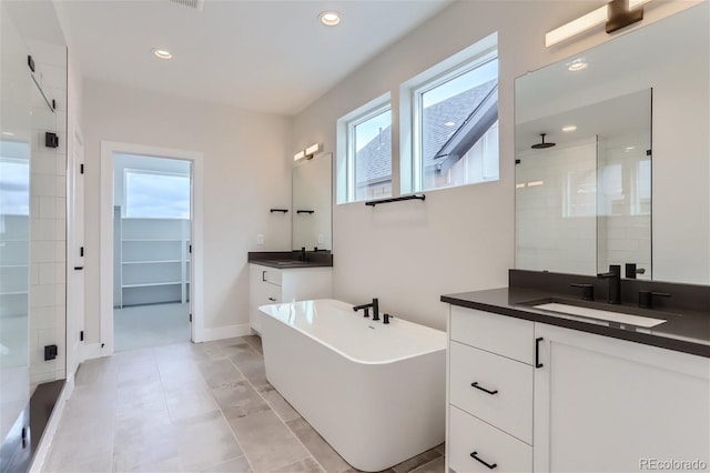 bathroom featuring vanity and independent shower and bath