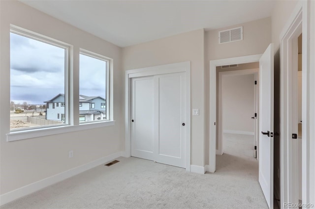 unfurnished bedroom featuring a closet and light carpet