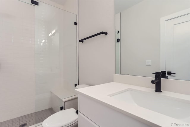 bathroom featuring vanity, toilet, and a tile shower