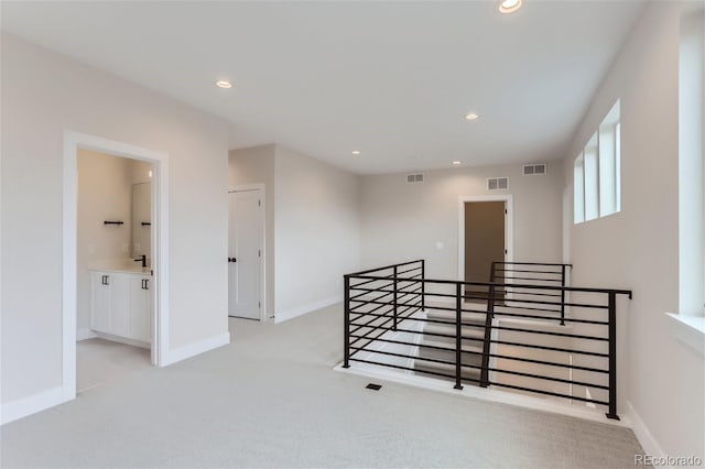 hall featuring light colored carpet