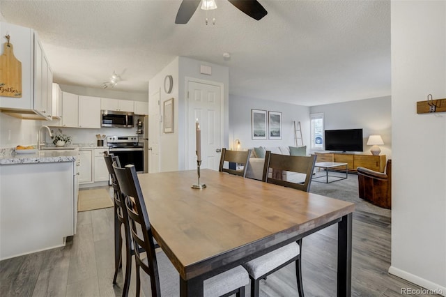 401 Forest Edge Rd Unit B1, Woodland Park, CO 80863 - dining room with ceiling fan, light wood-style floors, a textured ceiling, and baseboards