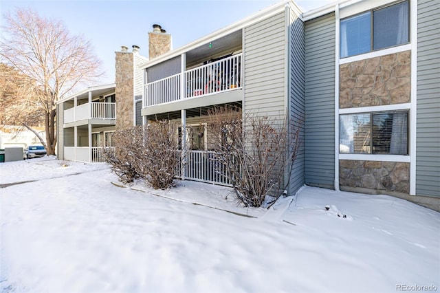 snow covered property with central air condition unit