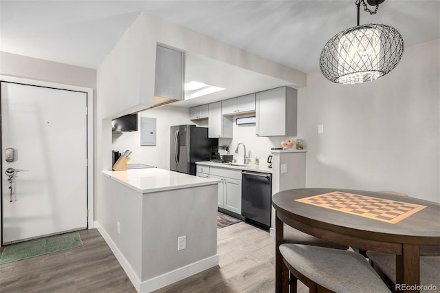 kitchen with black appliances, decorative light fixtures, light hardwood / wood-style floors, and sink