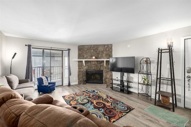 living room featuring hardwood / wood-style floors and a stone fireplace