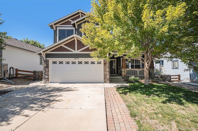 view of front of home with covered porch, a garage, and a front yard