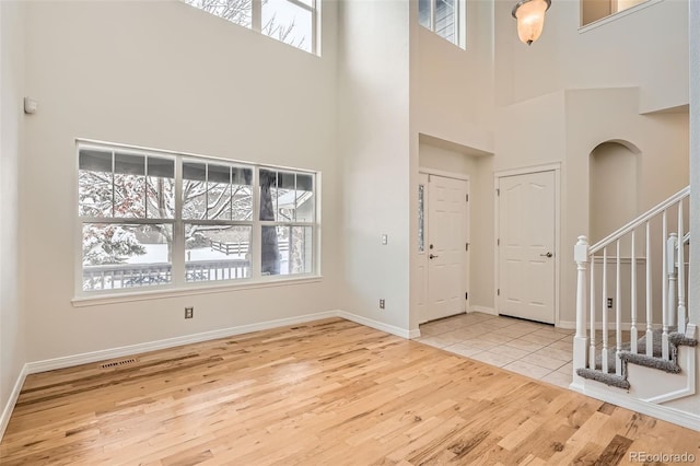 entryway with a high ceiling and light wood-type flooring