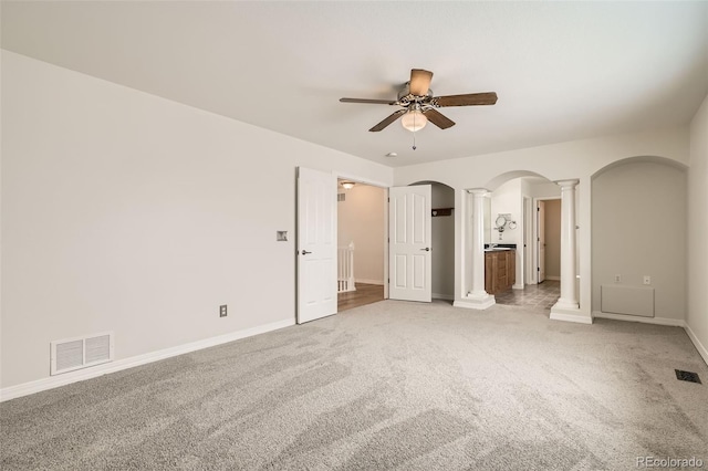 unfurnished bedroom featuring ornate columns, ceiling fan, and carpet floors